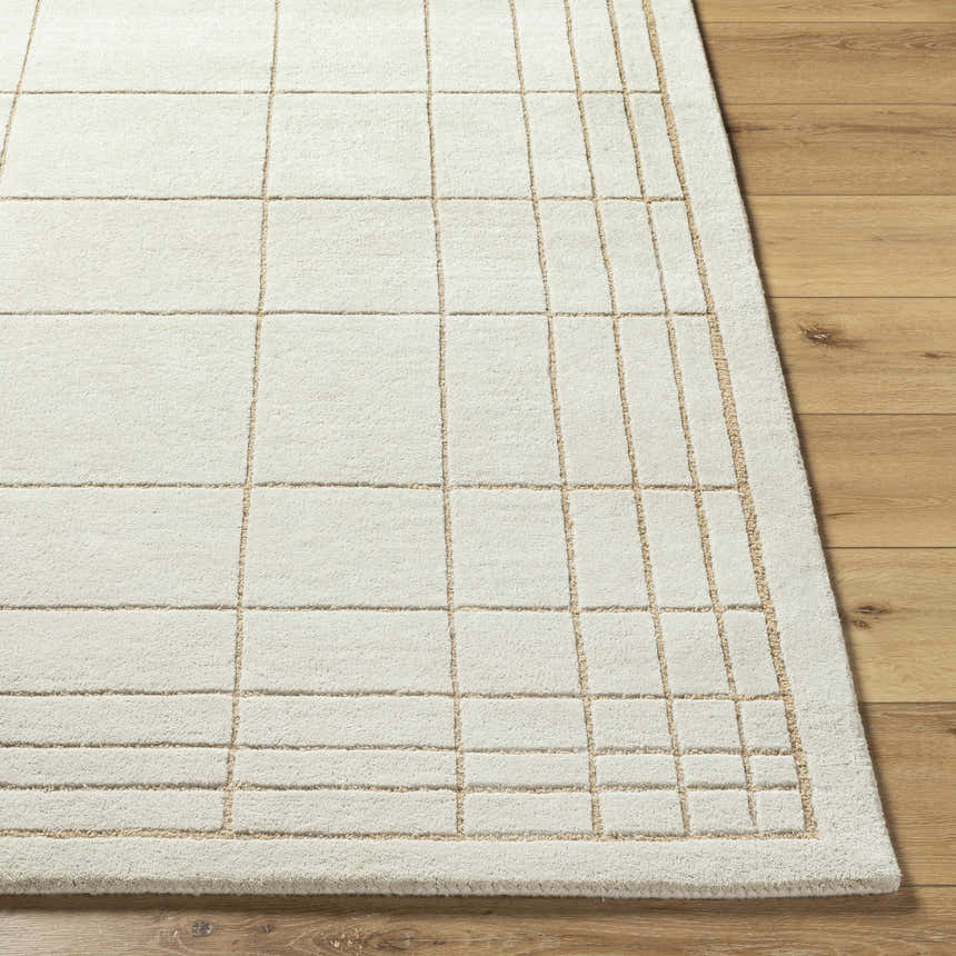 Close-up of the Sedna Wool Area Rug. Medium gray wool with a tan grid pattern on hardwood flooring. Front