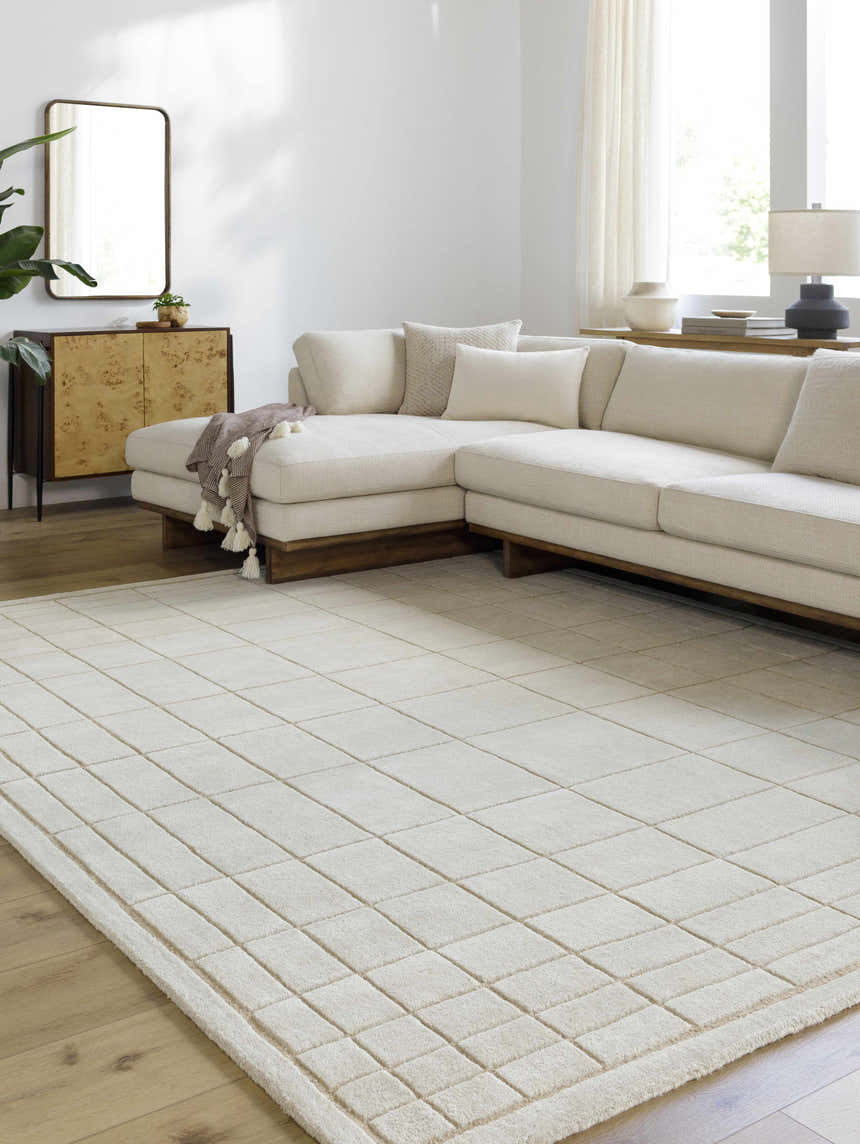 Living room with a neutral sectional sofa and a light gray Sedna Wool Area Rug with a geometric square pattern. Roomscene-Rectangle