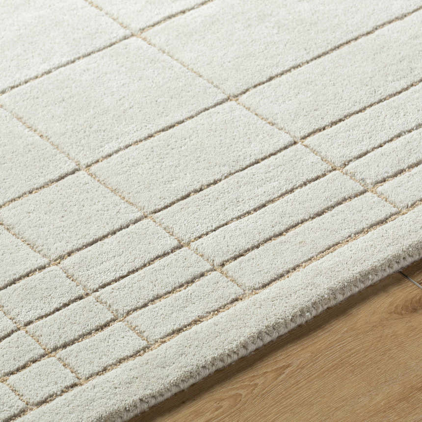 Close up of the Sedna Wool Area Rug showing its medium gray and tan geometric pattern. Texture