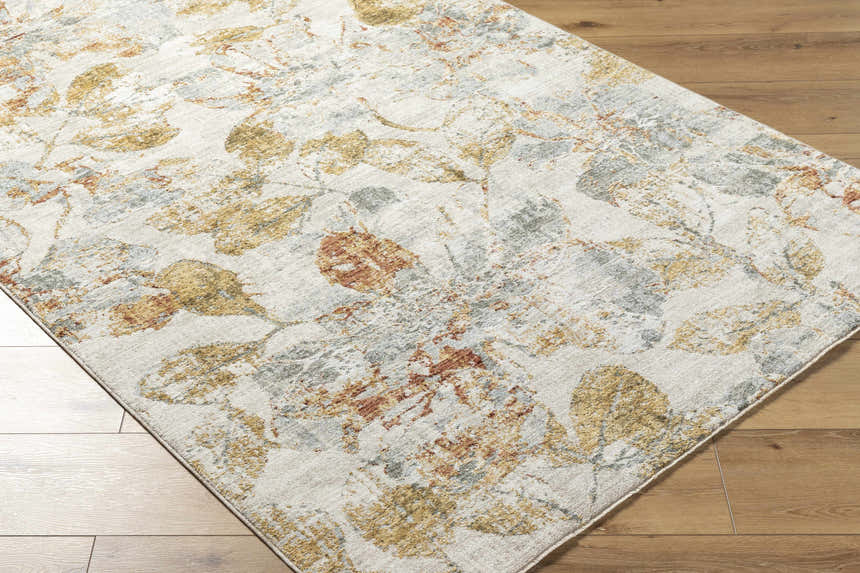 Close-up of the Ouida Floral Rug. Copper, light silver, and natural tones create a farmhouse-style floral pattern. Corner