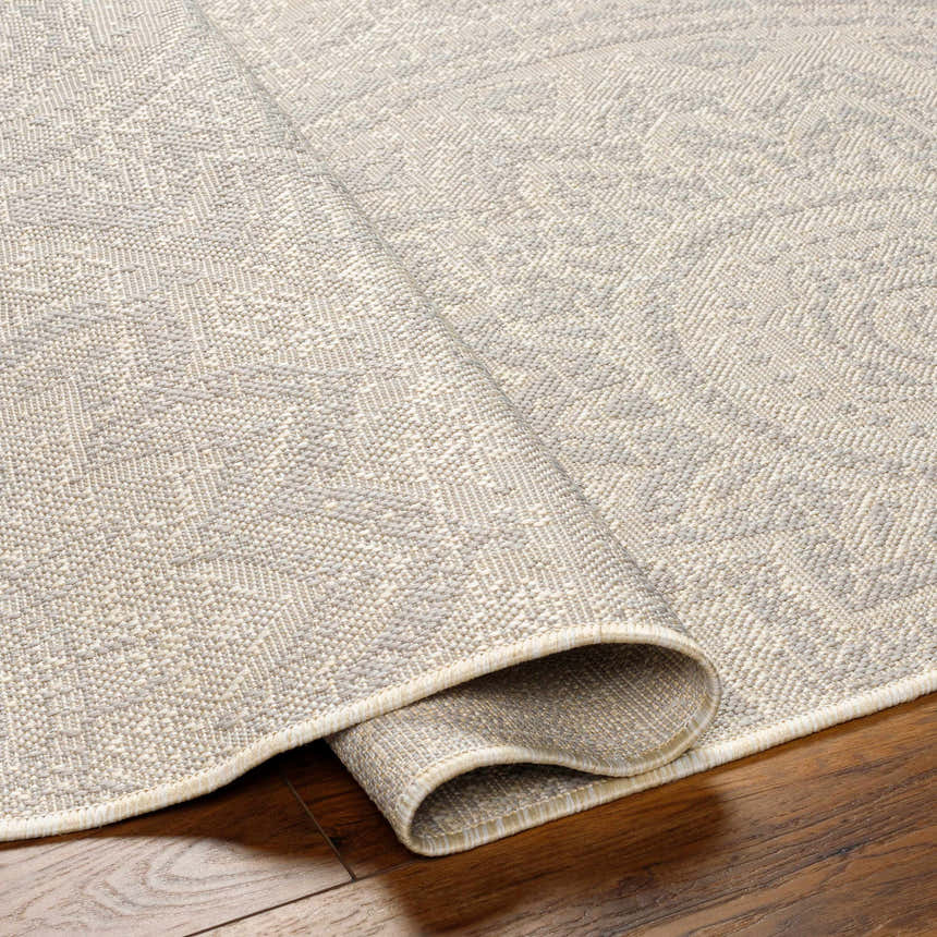 Close-up of the Ayala Cream Area Rug showing its neutral beige tones and subtle geometric pattern. Fold