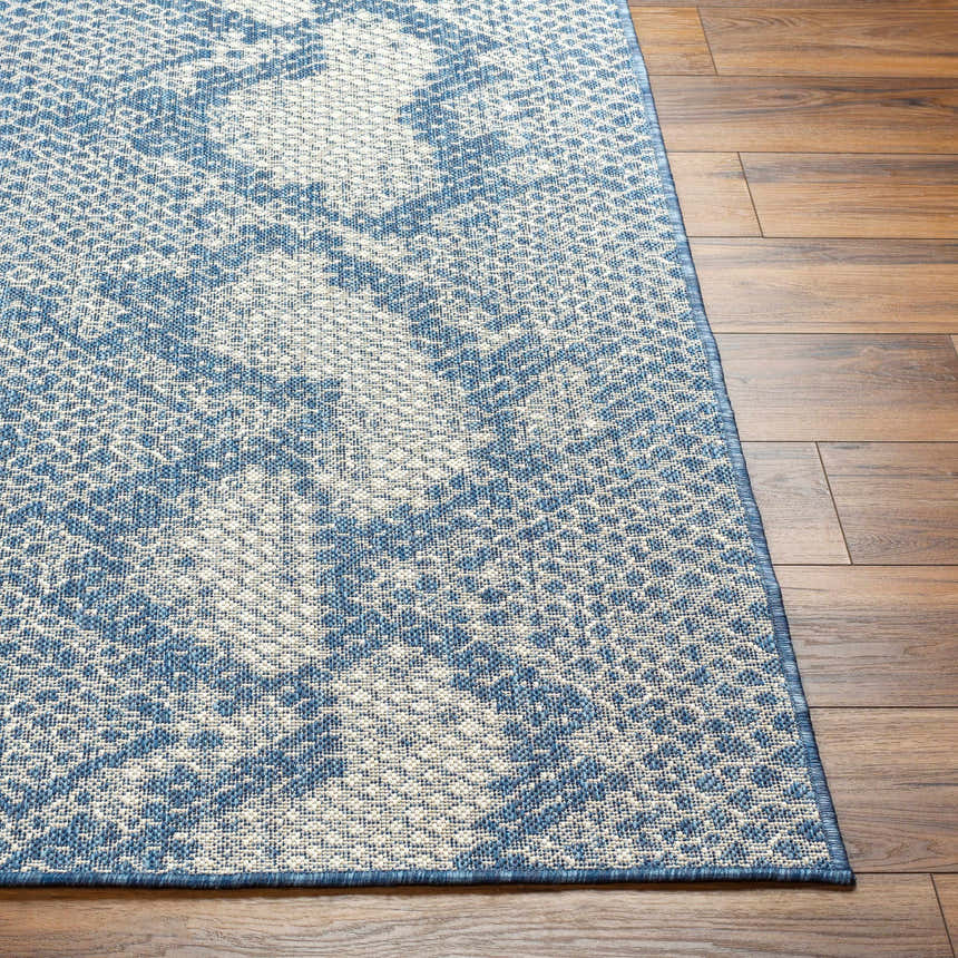 Close-up of Estee Blue Snake-Patterned Area Rug showing the blue and off-white animal print design and woven texture. Front
