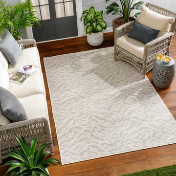Outdoor living room with Friso Cream Area Rug, wicker furniture, and potted plants. Beige and gray tones. Roomscene-Rectangle
