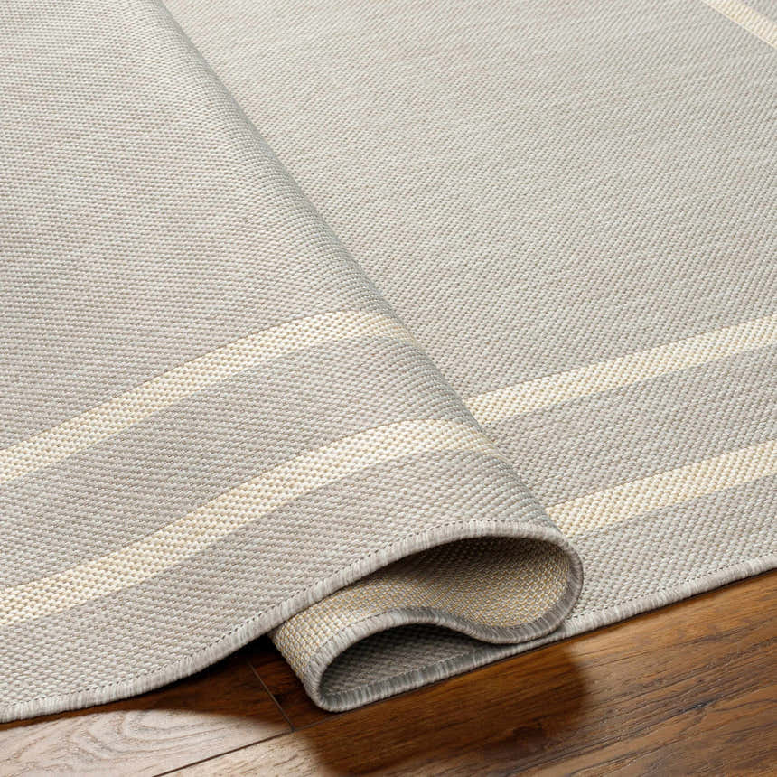 Close-up of the Ilori Light Gray Area Rug showing its woven texture and light gray and cream striped pattern. Fold
