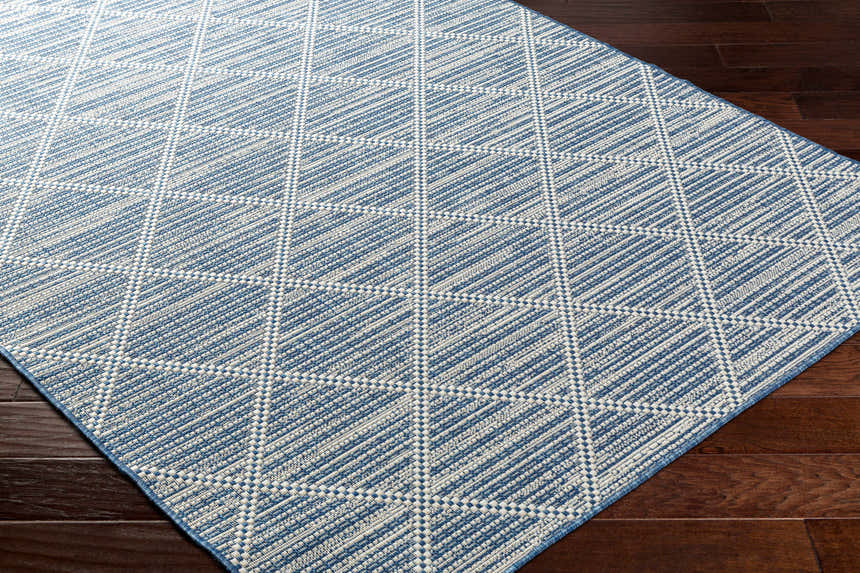 Close-up of the Ivora Blue Area Rug showing its textured, geometric diamond pattern in denim and white. Corner
