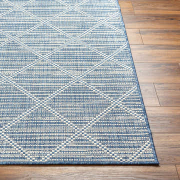 Close-up of the Ivora Blue Area Rug showing its contemporary geometric pattern and texture on hardwood flooring. Front