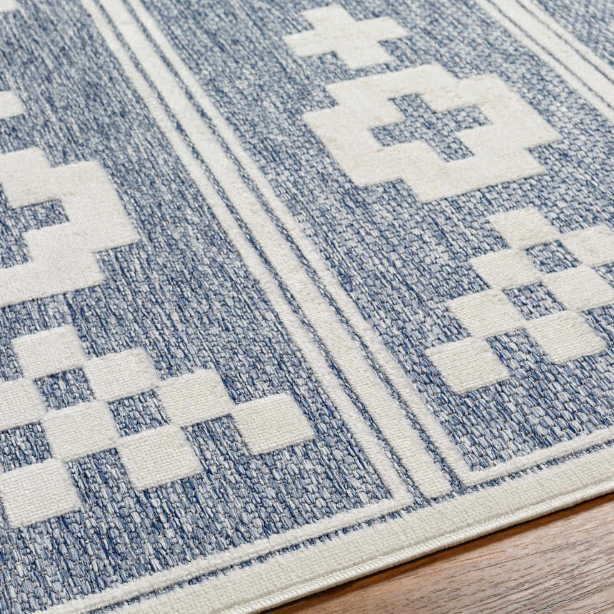 Close up of the Hiro Blue Outdoor Rug showing the denim and white geometric pattern. Texture