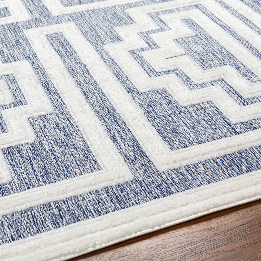 Close-up of the contemporary Yves Blue Outdoor Rug, featuring a geometric pattern in blue and white. Texture