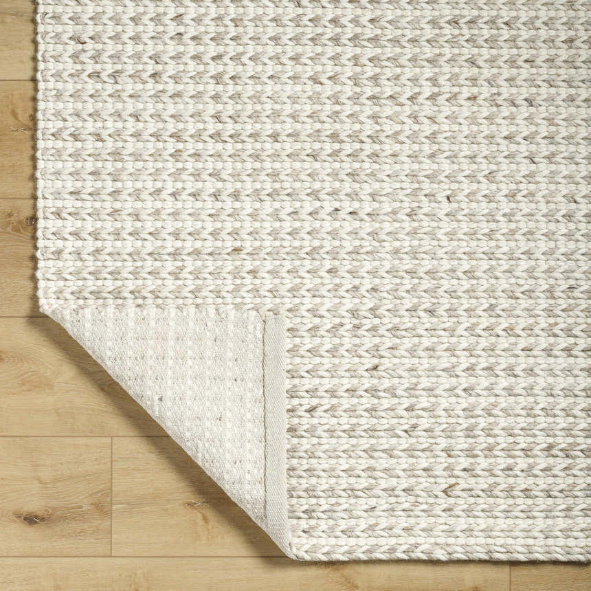 Close up of the hand woven Lenci Antique Beige Area Rug showing the wool and cotton texture. Fold