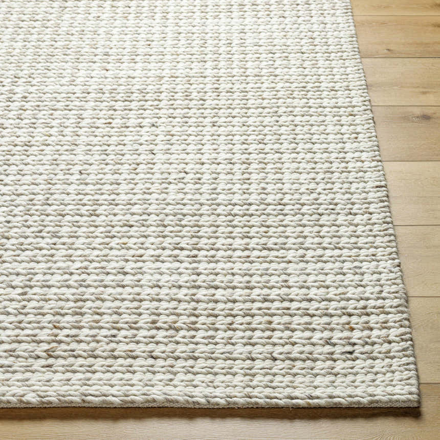 Close-up of the hand-woven Lenci Antique Beige Area Rug showing its wool and cotton texture on light wood flooring. Front