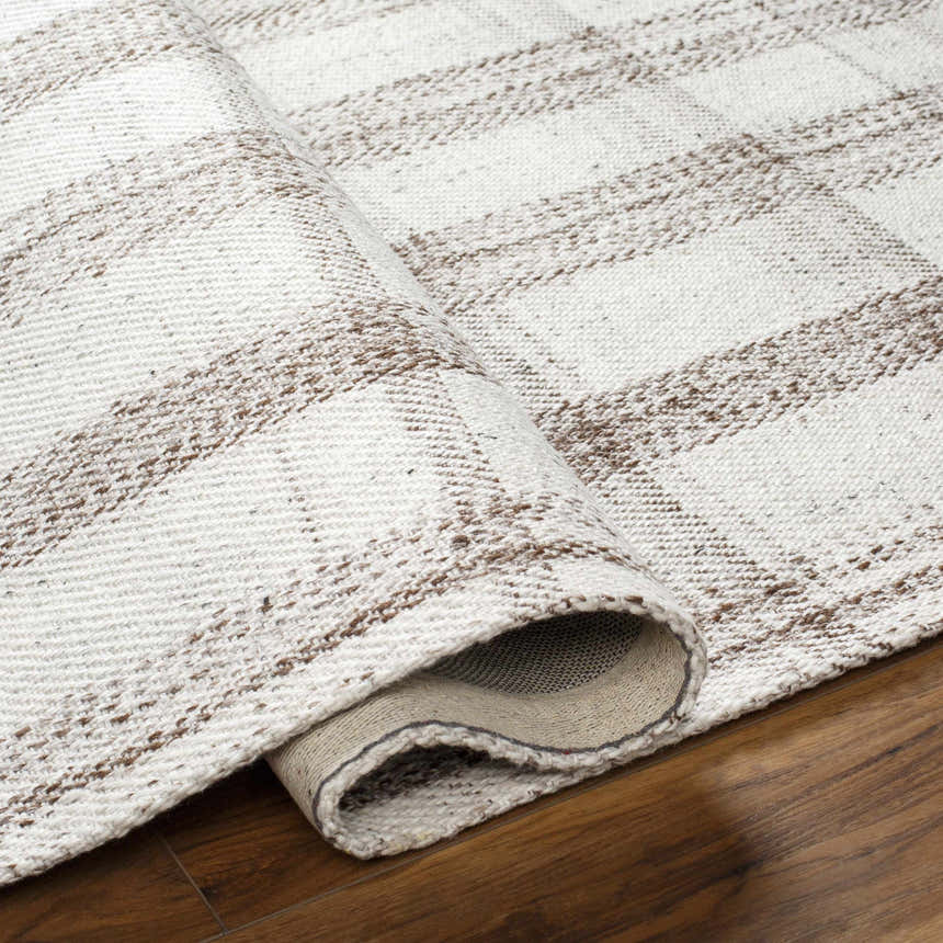 Close-up of the Leeba Beige Plaid Area Rug showing its hand-woven texture and neutral brown and cream plaid pattern. Fold