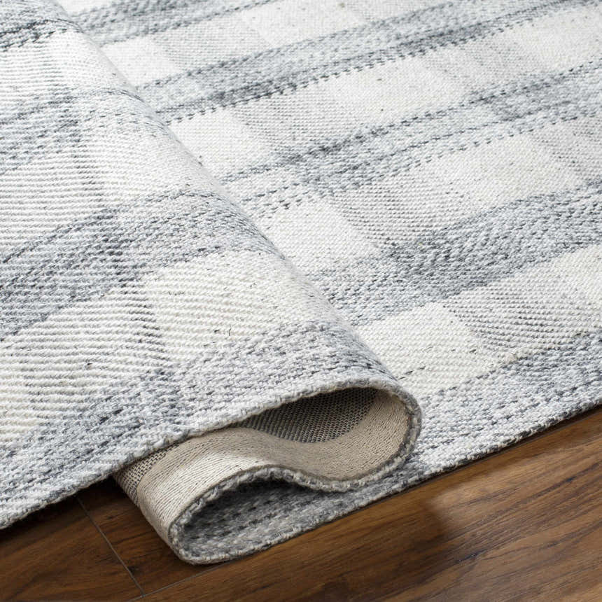Close-up of the hand-woven Leeba Gray Plaid Area Rug showing the gray and white plaid pattern and recycled PET yarn texture. Fold