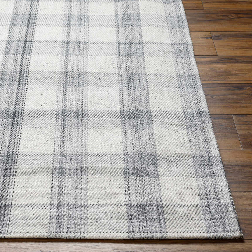 Close-up of the hand woven Leeba Gray Plaid Area Rug showing texture and pattern on dark wood flooring. Front