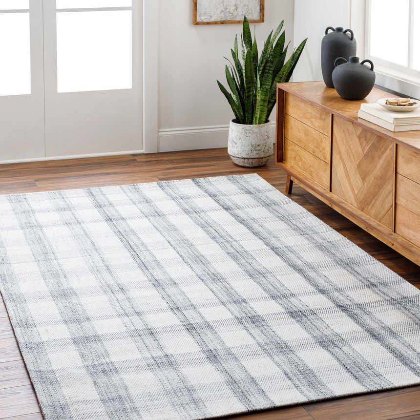 Living room with wood floors and Leeba Gray Plaid Area Rug. Farmhouse style with wood cabinet, plant, and neutral decor. Roomscene-Rectangle