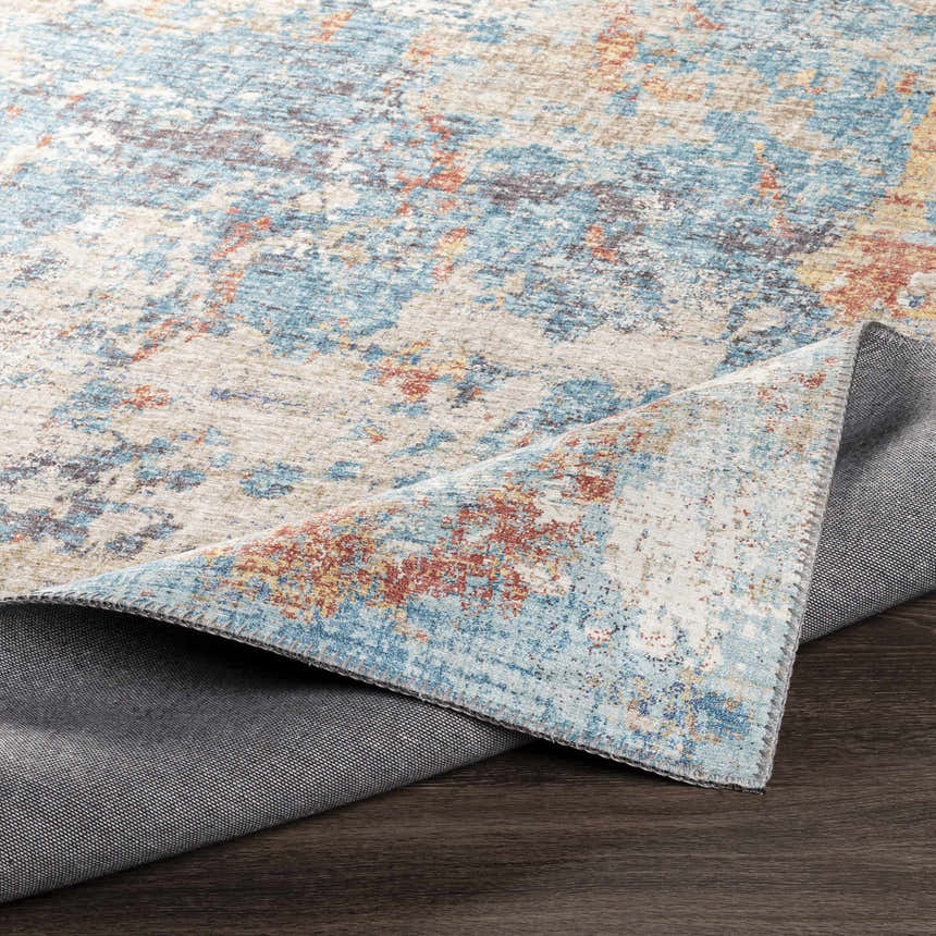 Close-up of the Stallingborough Area Rug showing its blue, cream, and brick red contemporary abstract design and texture. Fold