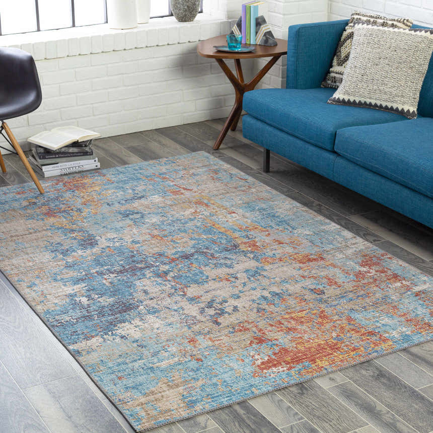 Living room scene with a blue sofa and Stallingborough Area Rug in blue, rust, and cream. Roomscene-Rectangle