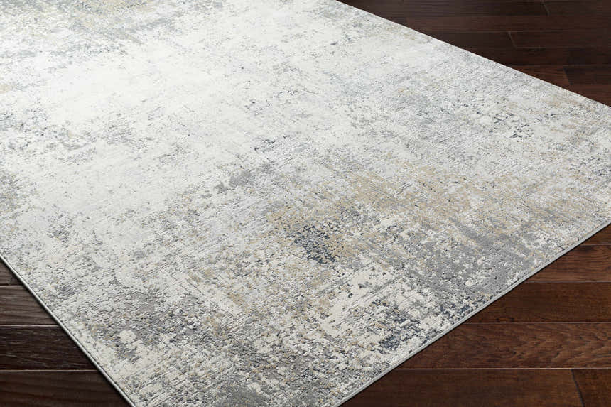 Close-up of Standlake Textured Luxe Area Rug in charcoal, cream, gray, and tan on dark wood floor. Contemporary style. Corner