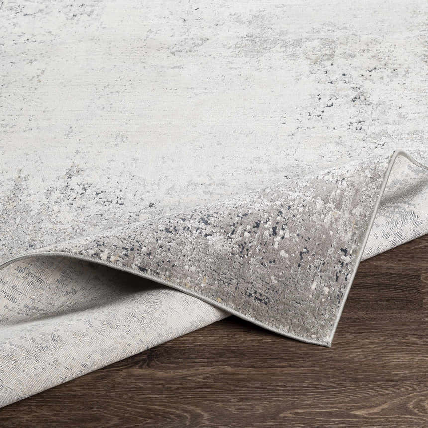 Close-up of the Standlake Textured Luxe Area Rug, showing its charcoal, cream, and gray textured design. Fold