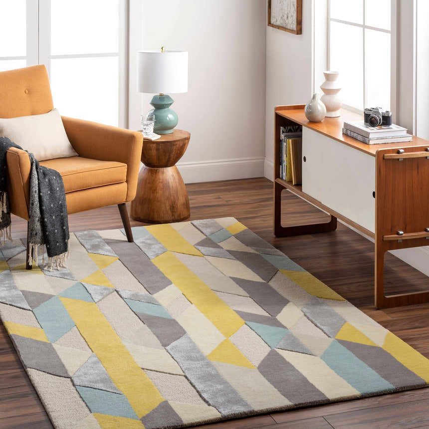 Living room scene with a Zoie Area Rug in camel, gray, and yellow geometric pattern. Mid-century modern style. Roomscene-Rectangle
