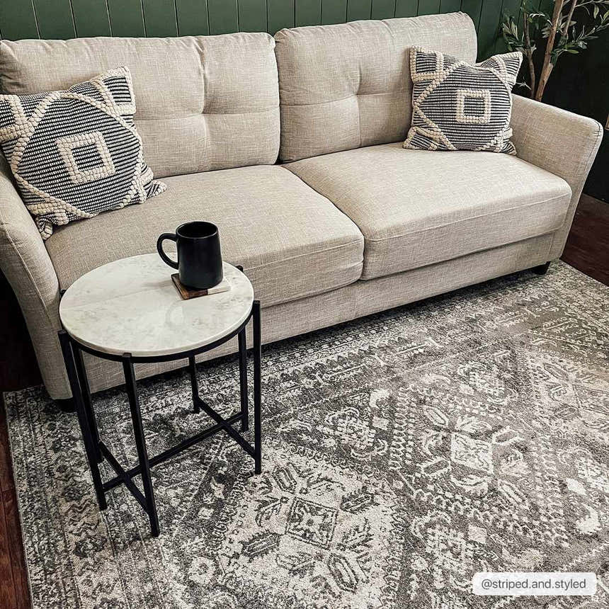 Living room scene with a Kingscourt Washable Area Rug in gray, beige sofa, and marble side table. Contemporary style. Roomscene-Rectangle
