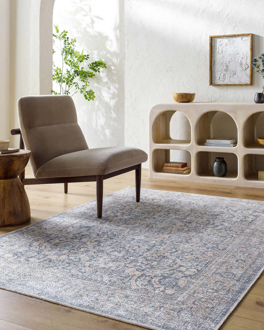 Living room scene with a blue and beige Orsin Washable Area Rug, gray chair, and light wood accents. Farmhouse style. Roomscene-Rectangle