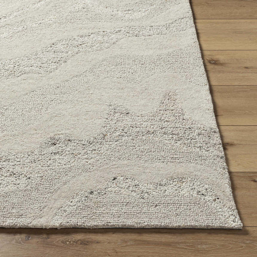 Close up of the Siani Cream Wool Area Rug showing its hand-tufted texture and ash and silver gray wavy pattern. Front
