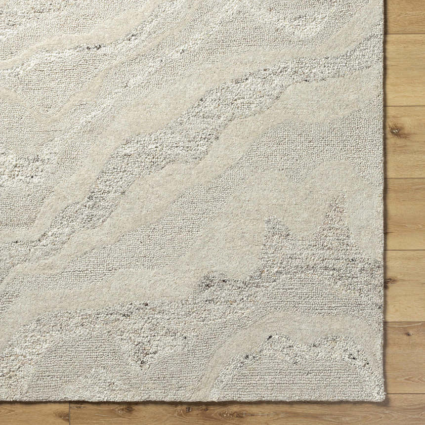 Close-up of the Siani Cream Wool Area Rug showing its ash and silver gray tones and hand-tufted texture. Corner