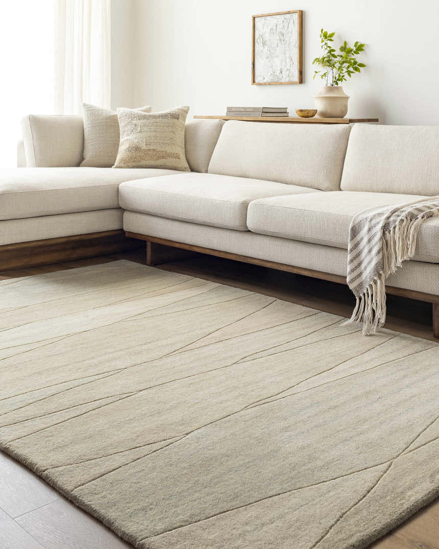 Living room scene with a tan Susie Modern Wool Rug, sectional sofa, and neutral decor. Roomscene-Rectangle