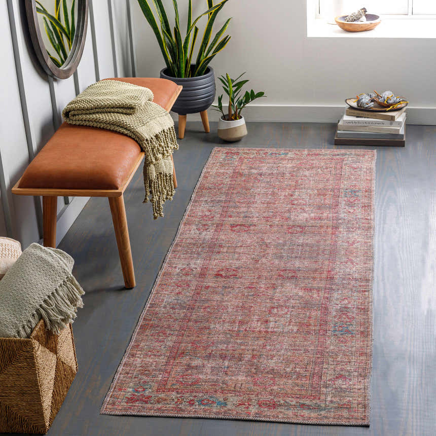 Entryway with Tajao Washable Printed Jute Rug, wood bench, woven basket, plants, and gray wood floors. Roomscene-Runner