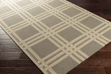Close-up of the Templeton Area Rug showing a gray and ivory geometric pattern on dark wood floors. Corner