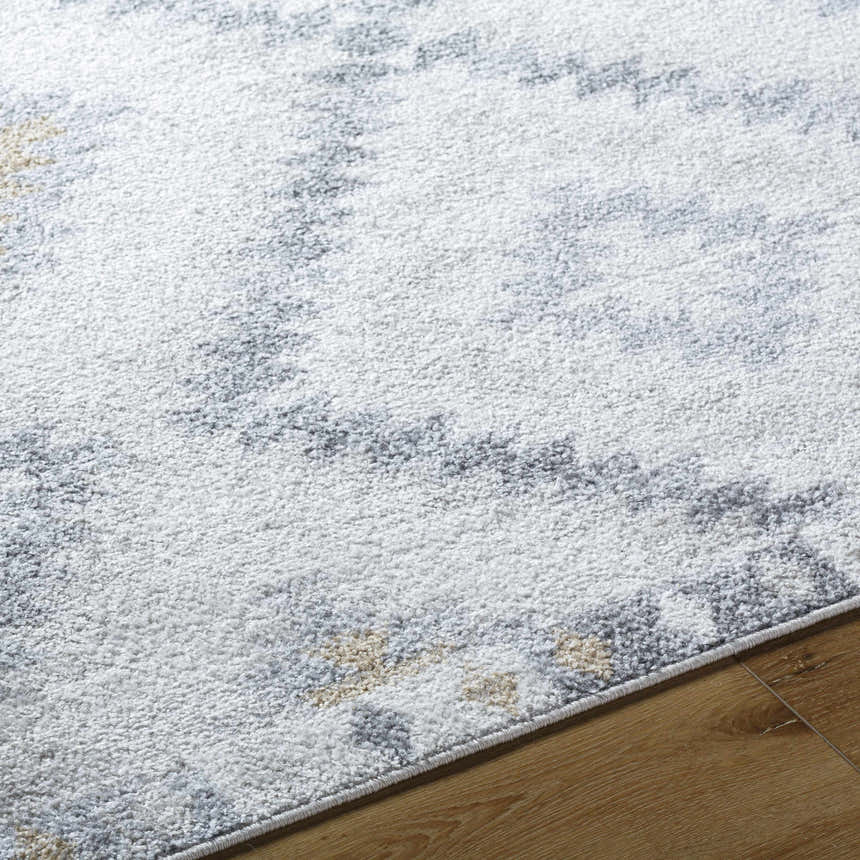 Close-up of the Tyipa Area Rug showing its charcoal, cream, gray, and mustard Southwestern pattern and soft texture. Texture