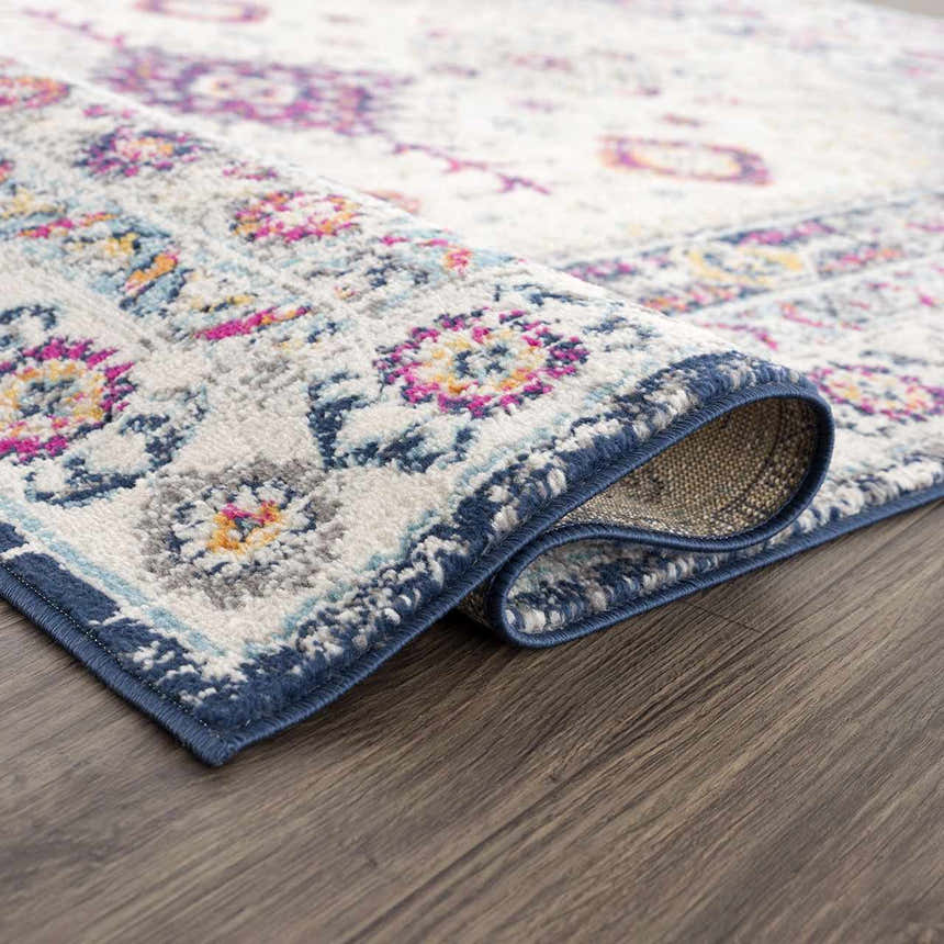 Close-up of Tigrim Beige 2306 Area Rug showing the bohemian floral pattern, ivory base, and navy border. Fold