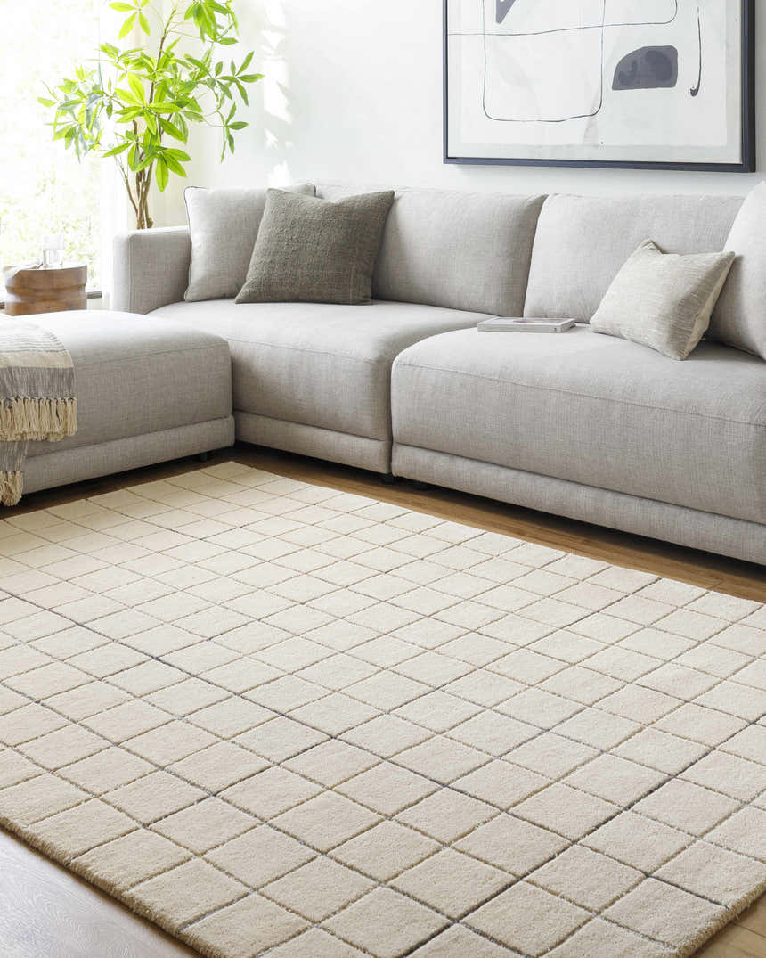 Living room scene with a gray sectional sofa and a Toshi Beige Area Rug with a geometric diamond pattern. Roomscene-Rectangle