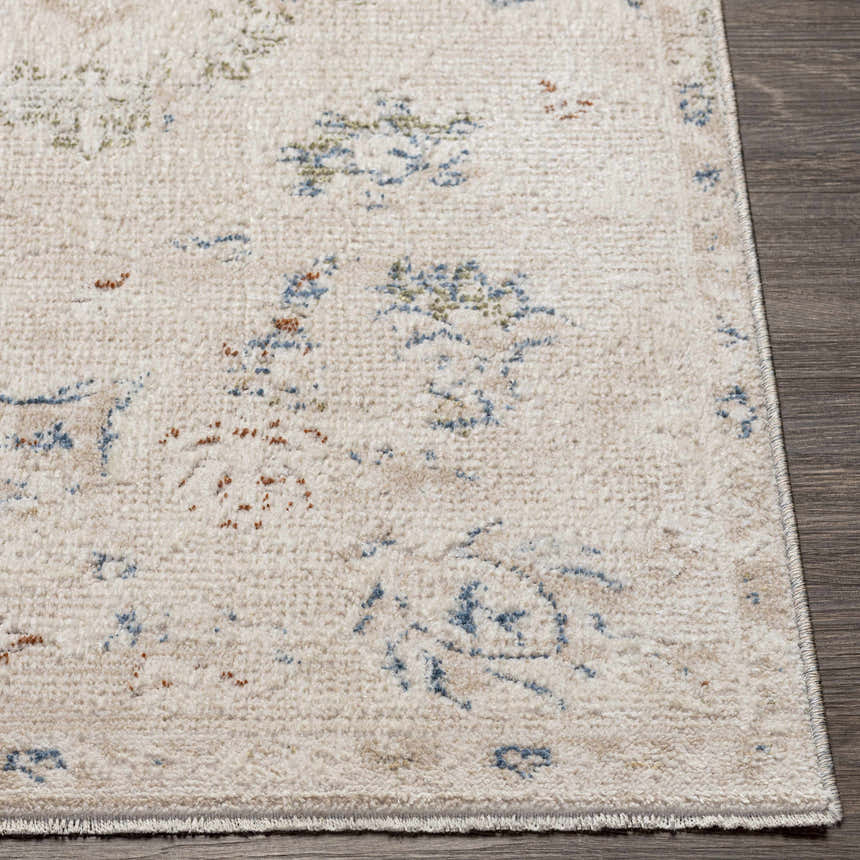 Close up of the Tinampo Area Rug, a machine-woven rug with a cream base and blue, olive, and rust colored accents. Front