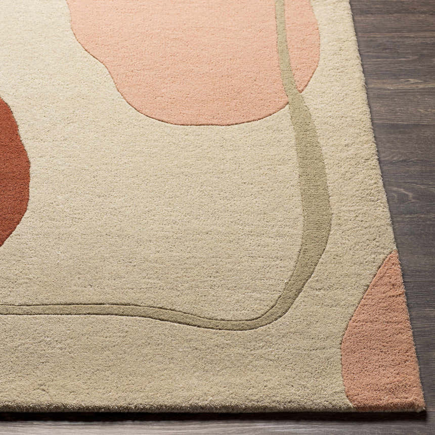 Close-up of the Tomingad Area Rug. Hand-tufted wool rug with a geometric design in brick red, dusty pink, oatmeal, and taupe. Front