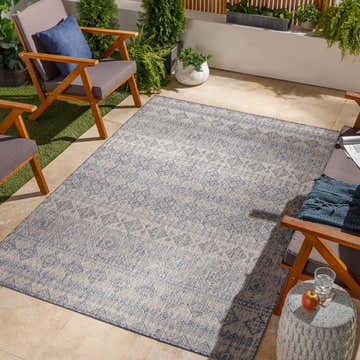 Outdoor patio scene with wood chairs and the Ramon Gray & Blue Area Rug. Roomscene-Rectangle