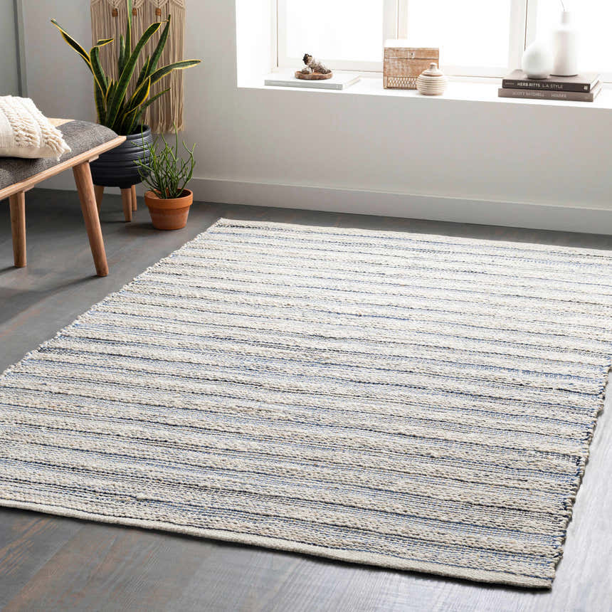 Living room scene with a beige and denim striped Totolan Area Rug, bench, plants, and natural light. Roomscene-Rectangle