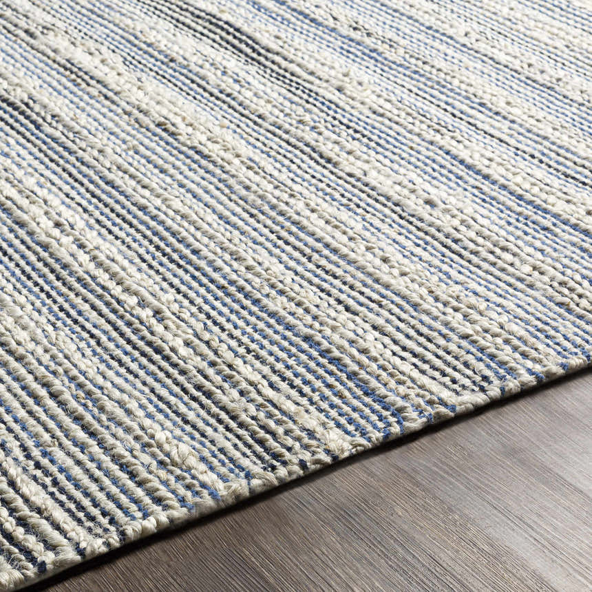 Close up of the hand woven Totolan Area Rug. Beige jute rug with denim and black stripes. Texture