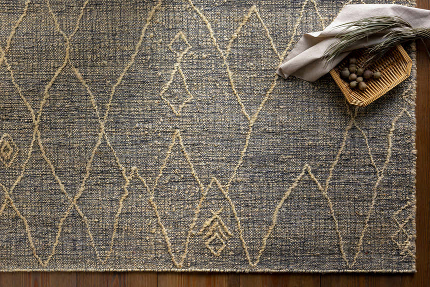Close-up of the Tregarth Area Rug. Hand-woven jute rug with a diamond pattern in natural and gray tones. Styleshot