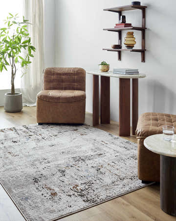 Living room scene with brown leather chairs and the Trejo Area Rug in dark brown, denim, mustard, taupe, and white. Roomscene-Rectangle