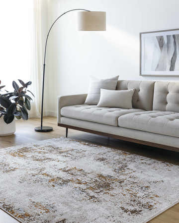 Living room scene with a neutral sofa and the Totie Area Rug in dark brown, denim, and mustard tones. Roomscene-Rectangle