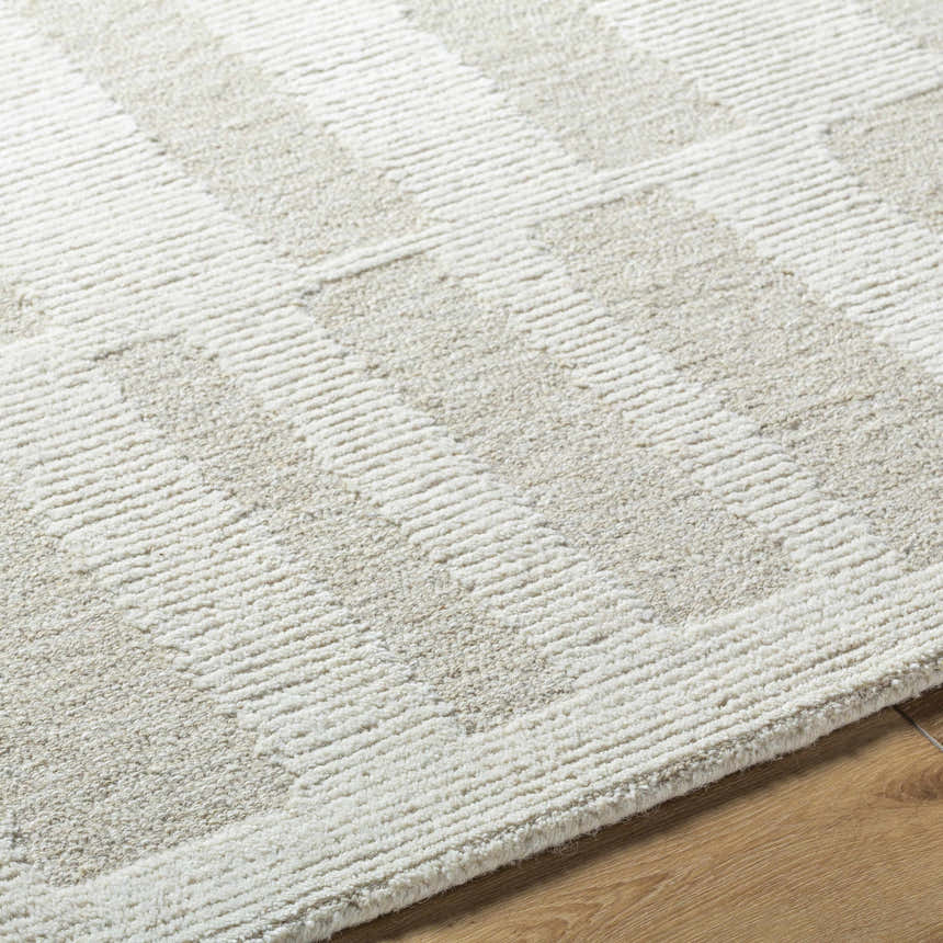 Close-up of the hand-tufted Teige Light Silver Area Rug. The wool rug has a subtle geometric pattern and soft texture. Texture