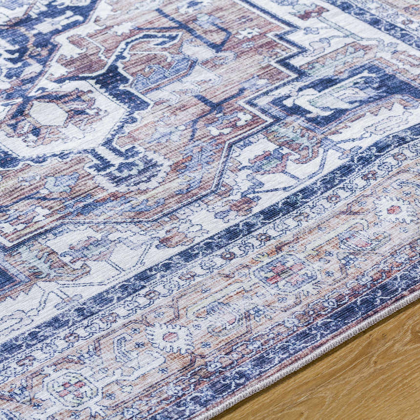 Close-up of Terri Washable Area Rug showing traditional beige, black, cream, and dark red pattern. Texture