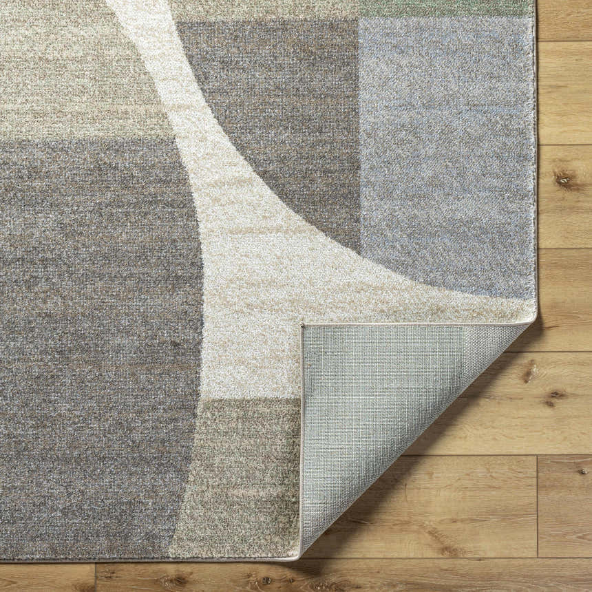 Close-up of Trini Taupe Geometric Area Rug showing charcoal, cream, and light brown tones. Machine woven texture. Fold