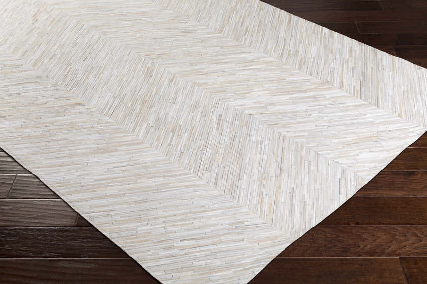 Close-up of Upland Premium Rug. Brown, cream, and gray hair on hide rug with a contemporary chevron pattern. Corner