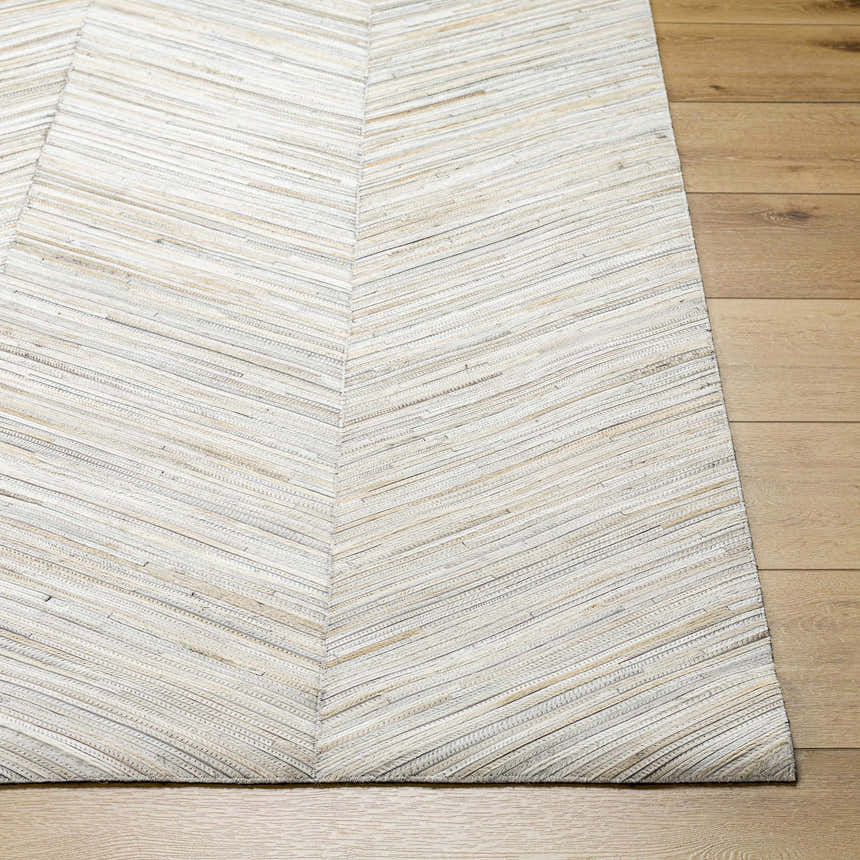 Close-up of the Upland Premium Rug. Brown, cream, and gray hair on hide rug with a subtle chevron pattern. Front