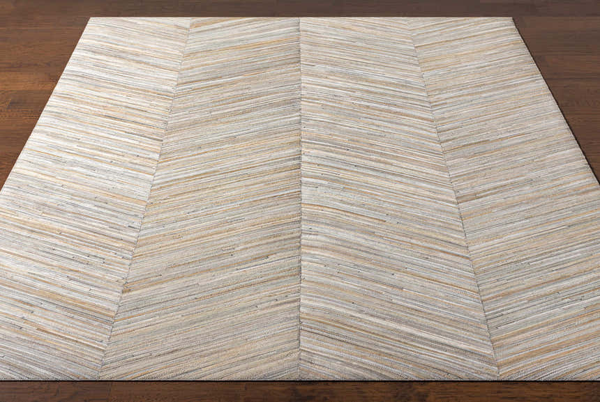 Close-up of Upland Premium Rug showing brown, cream, and gray tones in a chevron pattern. Hand-crafted hair on hide texture. Front