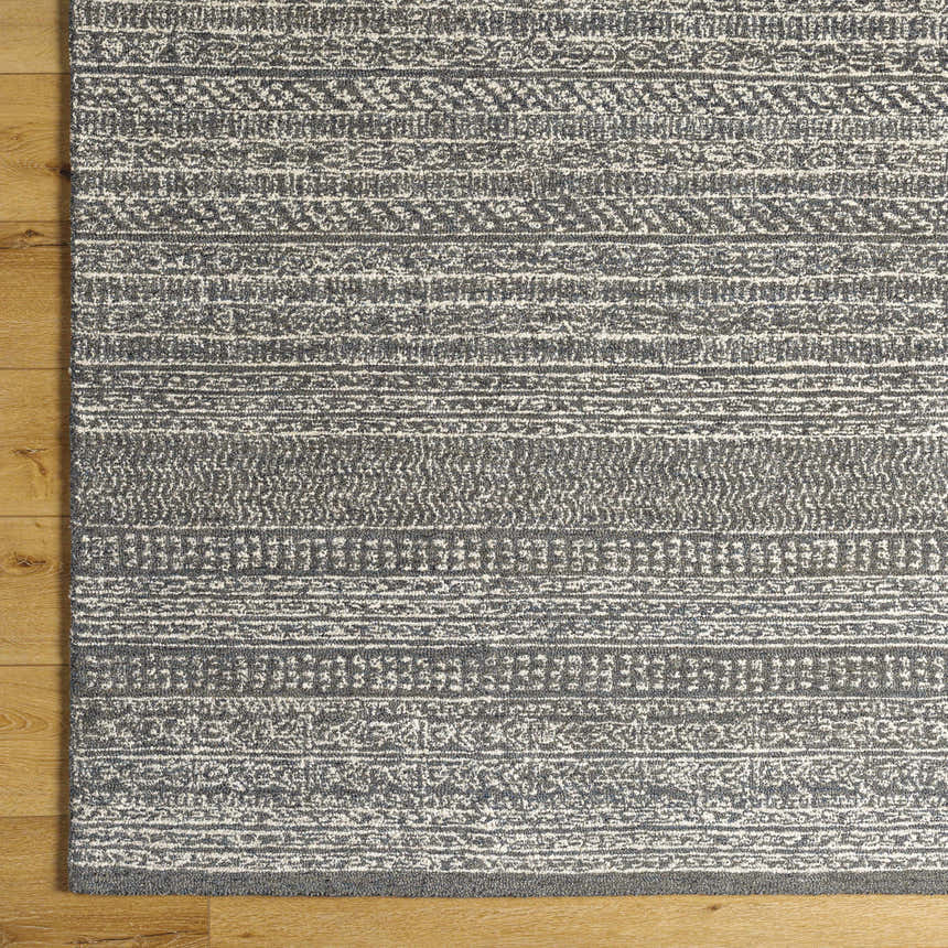 Close up of the hand tufted Urvi Area Rug. Gray and smoke wool rug with a farmhouse Moroccan-inspired pattern. Corner