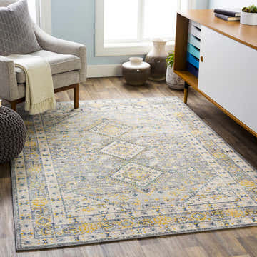 Living room scene with Varnville Area Rug in aqua, blue, mustard, and gray. Contemporary style with gray armchair and modern cabinet. Roomscene-Rectangle