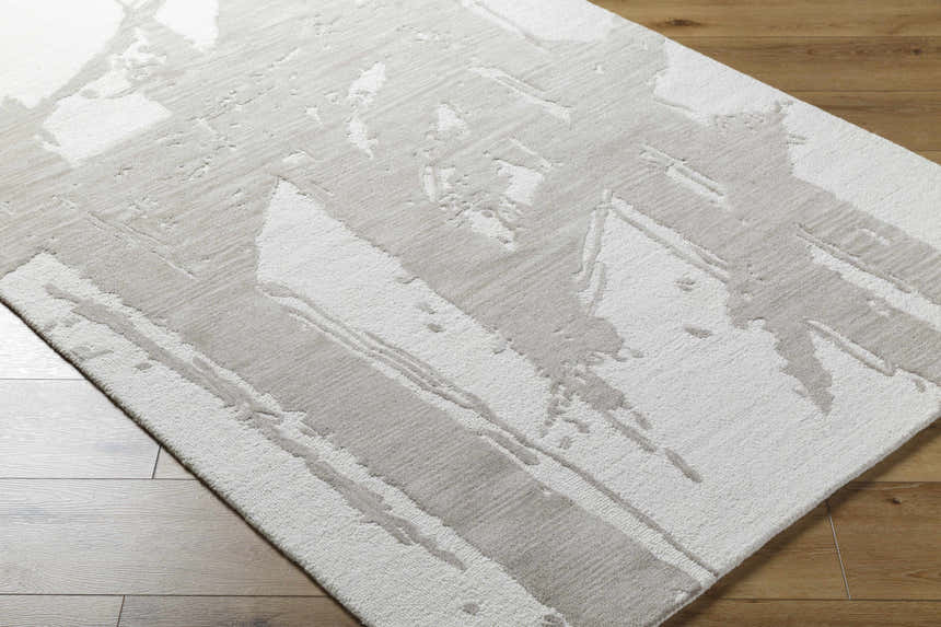 Close up of the Viven Ivory Area Rug showing its abstract silver gray and ivory pattern. Corner